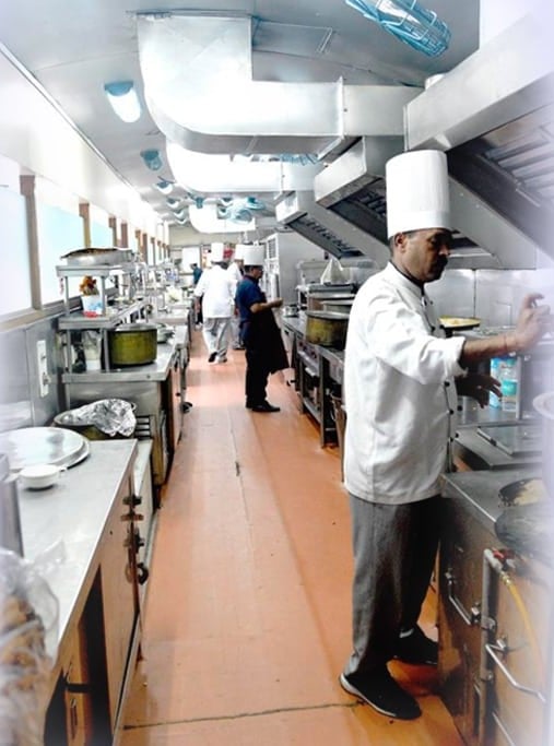 Chefs preparing food in the Palace on Wheels onboard kitchen car